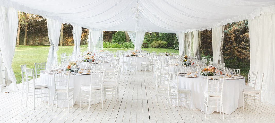 Outdoor wedding set up with white decor and canopy