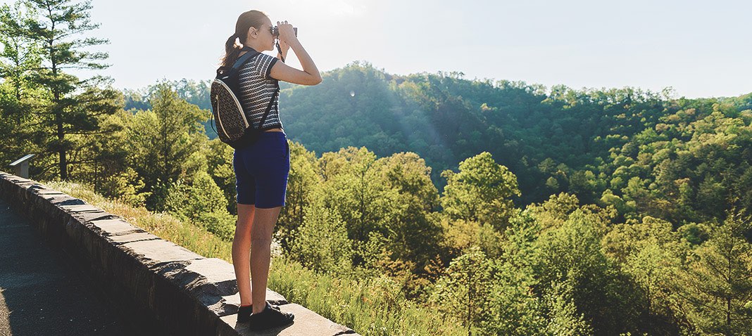 Woman looking at nature through binoculars