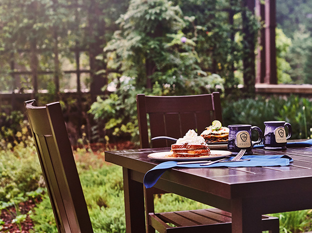outdoor dining with sewanee inn mugs and french toast and trees in background