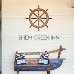 a boat turned into a seating space with the words "Shem Creek Inn"