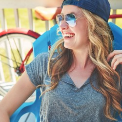 a girl laughing while lounging on a chair
