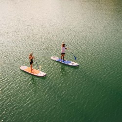 two people paddle boarding on the water