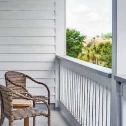 two wicker chairs on a large balcony painted white