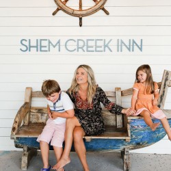 a family sitting in front of a sign that says "Shem Creek Inn"