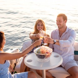 three people toasting drinks on a yacht