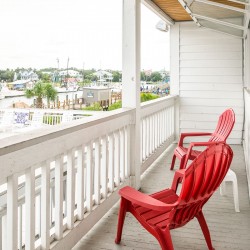 a balcony with two red lawn chairs