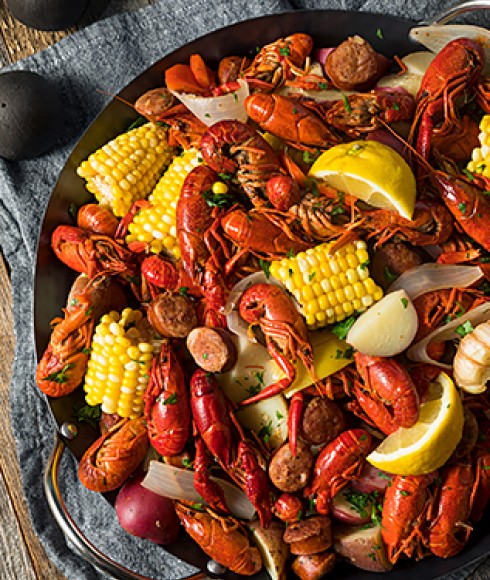 view of a crab dish with lemons and corn
