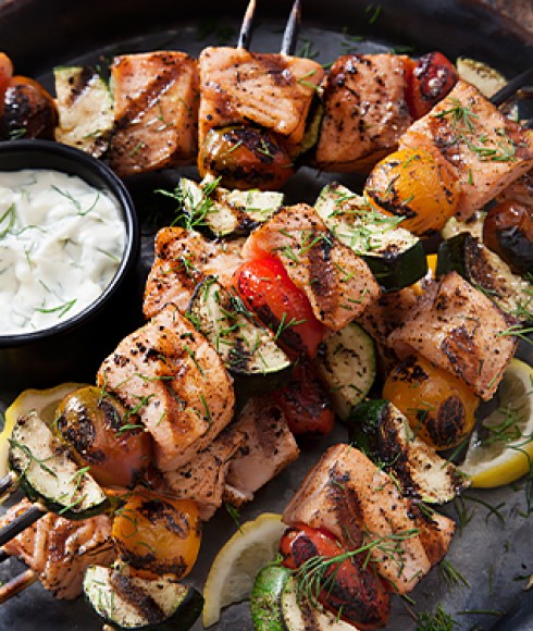 a plate of chicken and vegetables kabobs