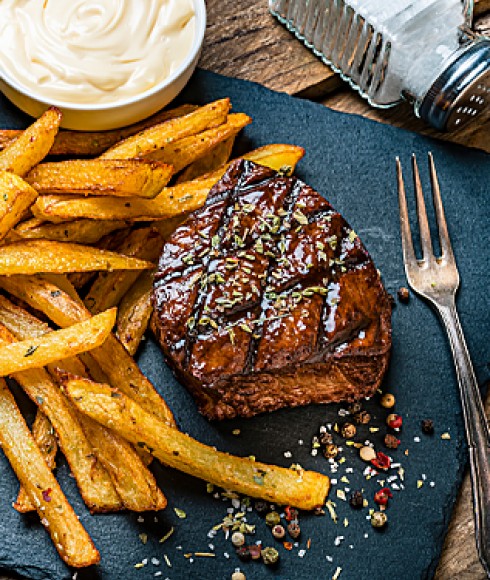 a blue plate with steak and fries