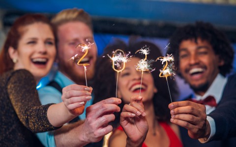 people holding sparklers and smiling