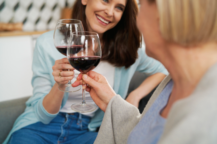 two ladies toasting their wine glasses