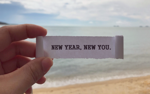 Person holding a piece of paper that says new year, new you.