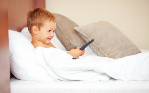 a child watching tv in bed
