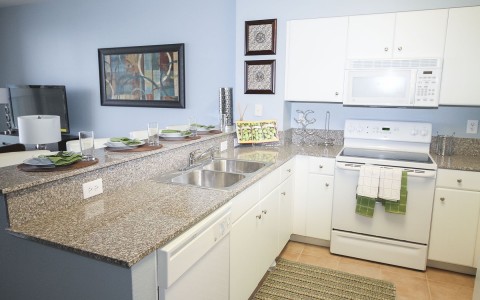 a white kitchen with granite countertops