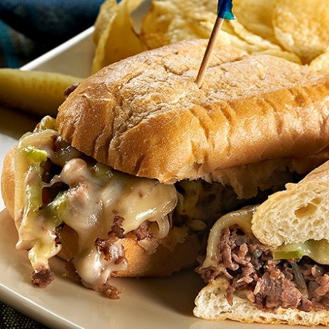 steak and cheese sandwich on a plate with chips