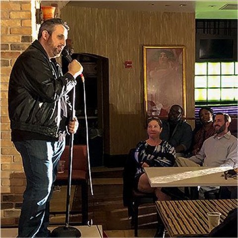 man on stage talking into a microphone