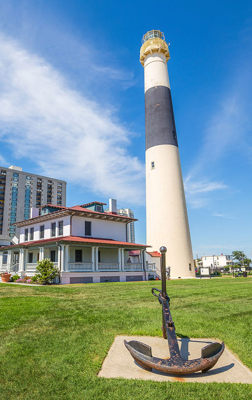 Lighthouse on green field with anchor