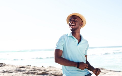 man laughing on a beach