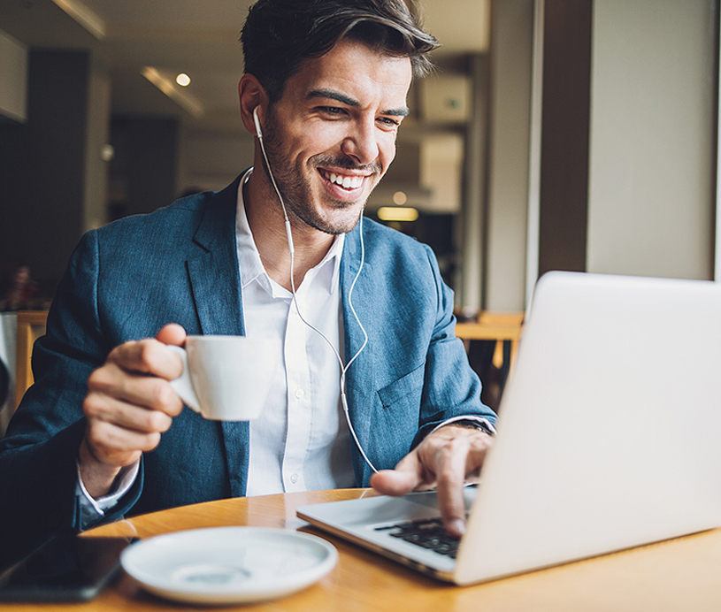 man drinking coffee and looking at a computer