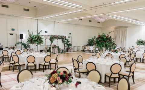 indoor wedding reception with floral centerpieces on round tables