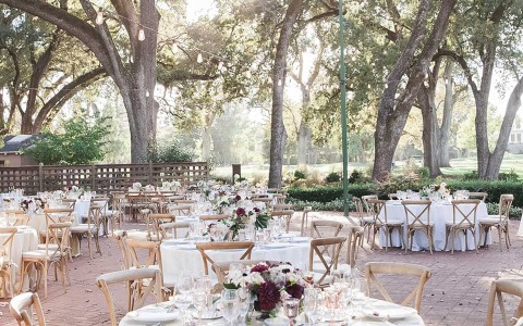 outdoor reception area with white decor and trees in the background 
