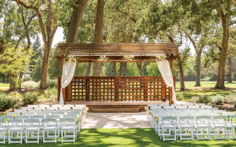 outdoor wedding venue under shaded area with wooden altar area 