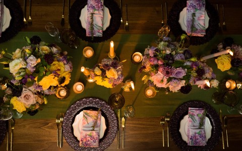 aerial view of reception table with yellow and purple decor and flower center pieces 