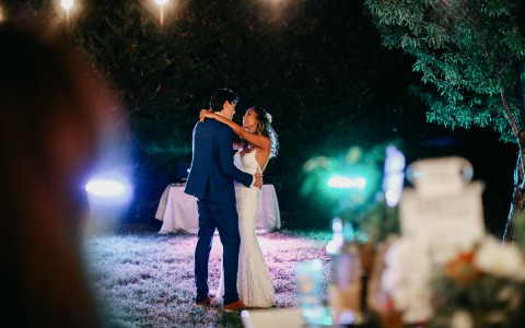 bride and groom dancing with lights shining on them at night 