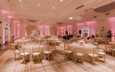 indoor ballroom reception with round tables and chairs