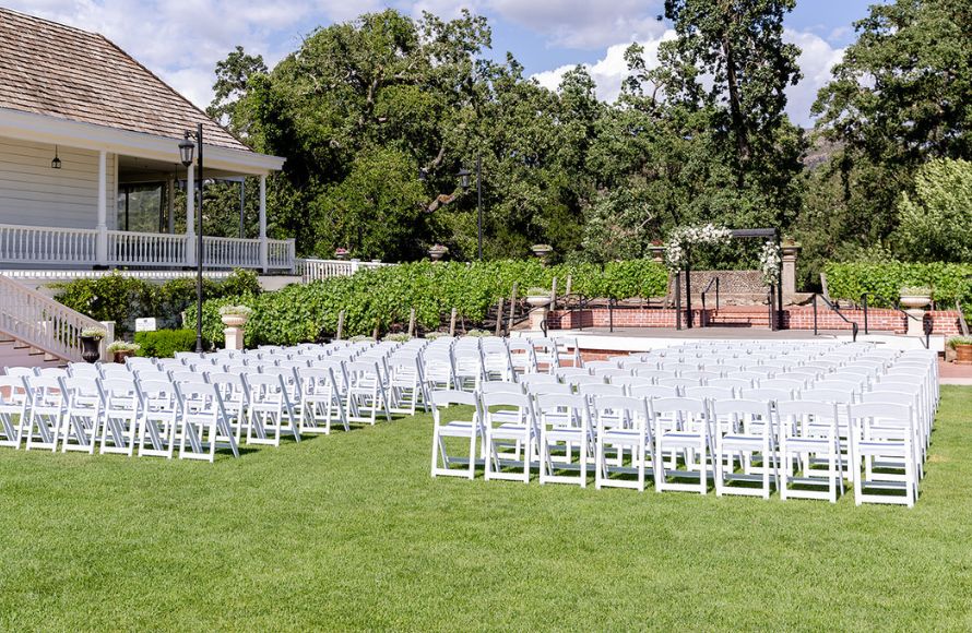 outside wedding venue with red table covers and white decor