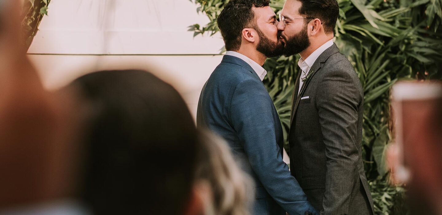 a gay couple kissing at the wedding