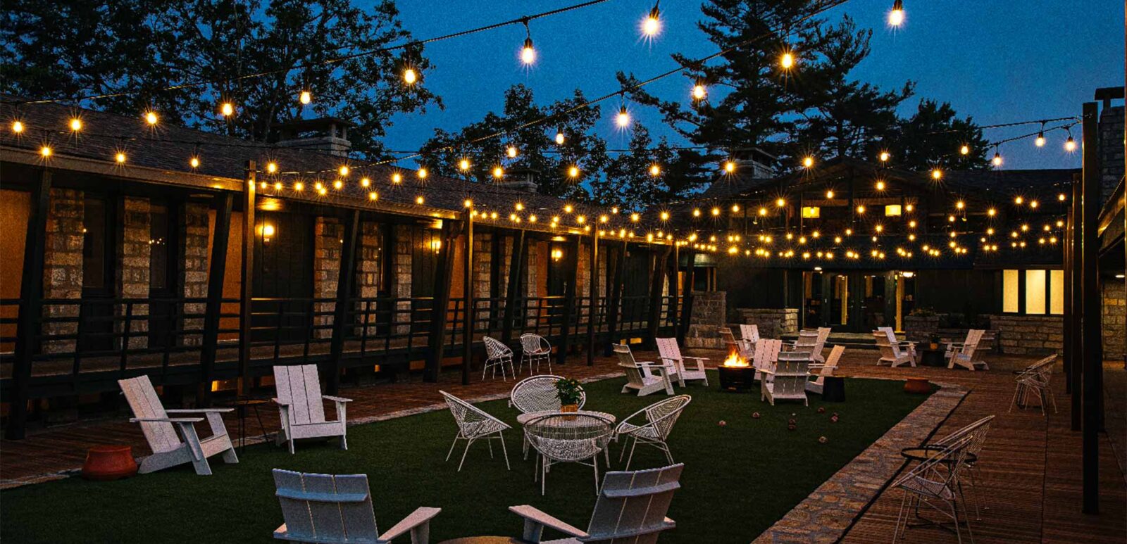 a patio with tables and chairs lighting up with fairy lights