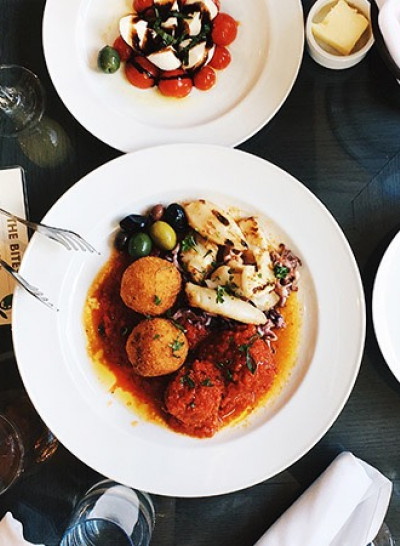 overhead view of italian dishes and a side of bread on a restaurant dining table