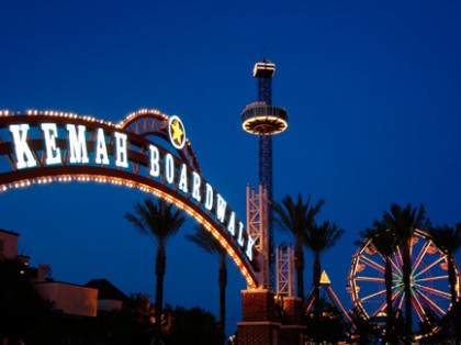 Kemah Boardwalk sign with fair rides in the background