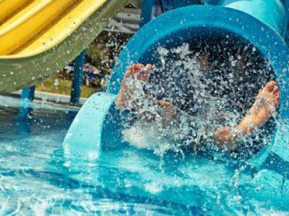 feet coming out of a waterpark tunnel slide