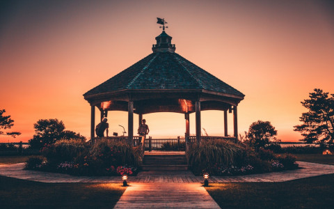 gazebo with people on bikes during the sunset