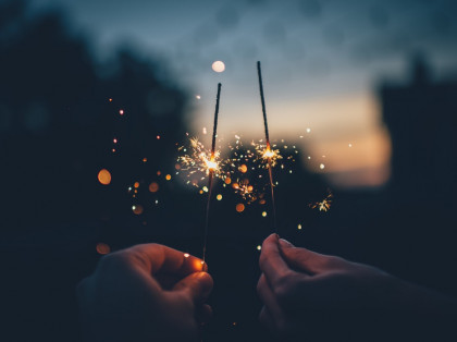 hands holding sparklers during dusk outside