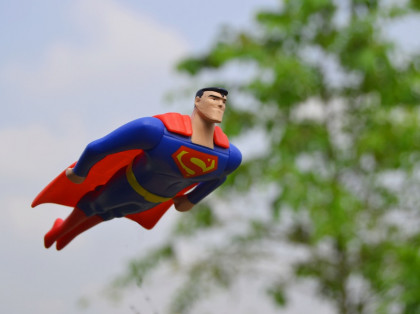 superman action figure flying in the sky