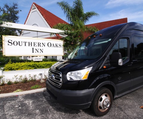 black shuttle bus parked in front of the southern oaks inn sign 