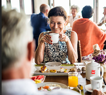 Woman at table with man drinking coffee