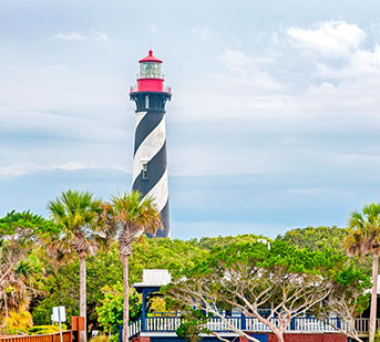 black and white striped lighthouse with red top