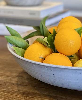 closeup view of mini oranges on a bowl plate in the table