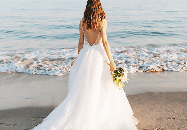 Bride in the beach looking at the sea