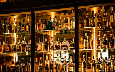bar shelves with dark liquors neatly organized on them