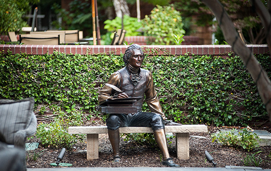 Bronze statue of writer sitting on a bench