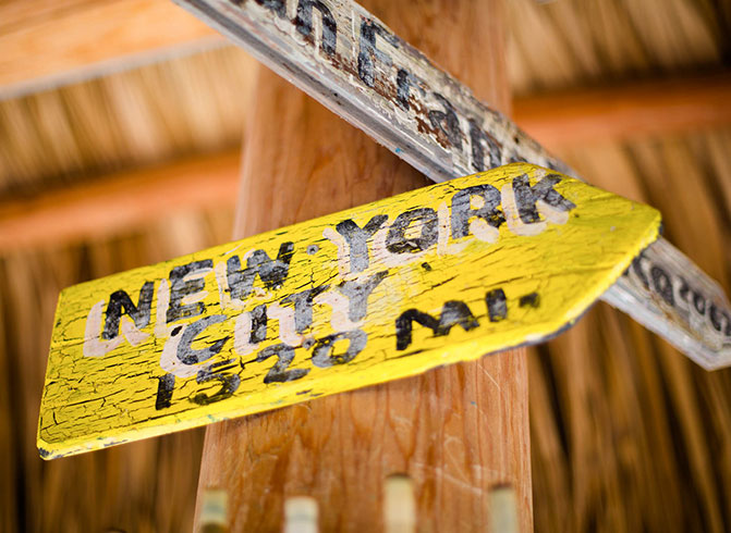 yellow sign hanging on a wooden post