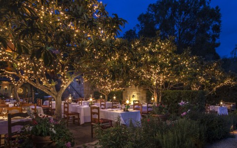 outdoor dining patio at night with lights in the trees