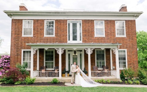 Couple married posing in front of the Stover Main House