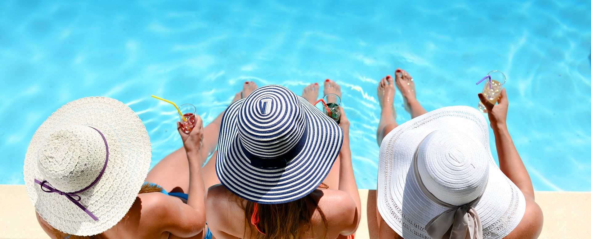 three friends sitting by the pool