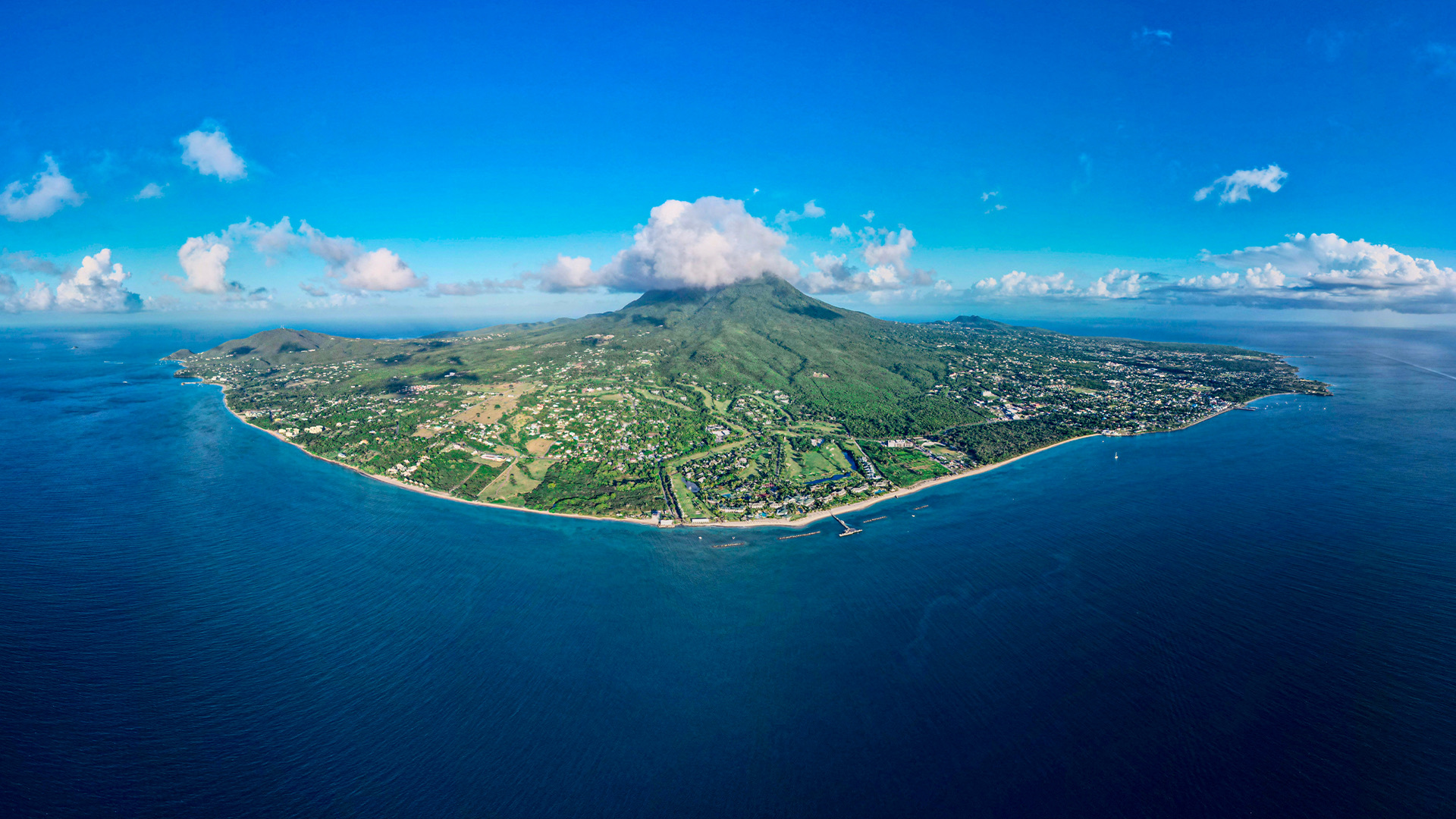 Aerial view of the island with clouds covering the top of the mountain.